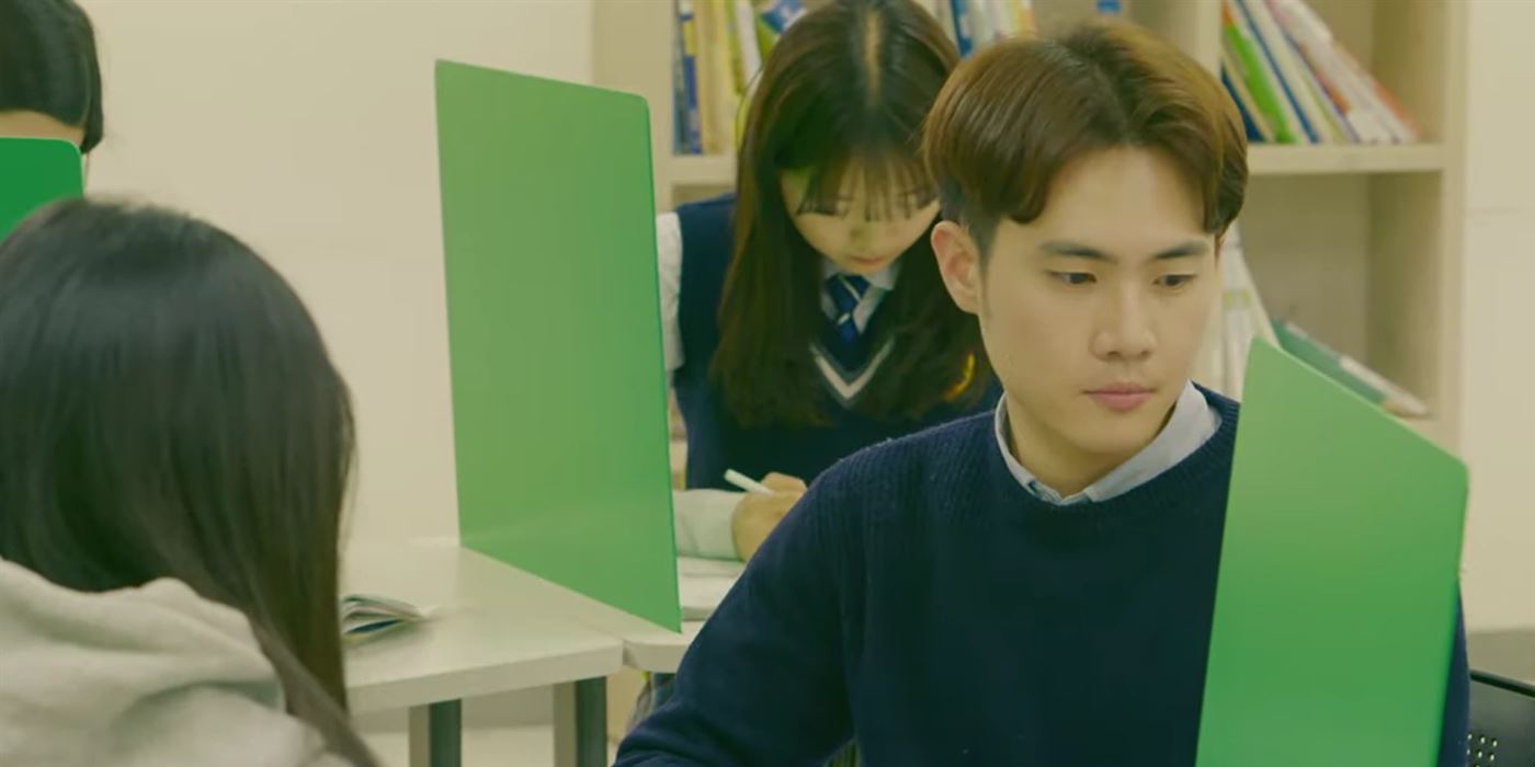 선생님이 학생 옆에서 1:1로 공부를 봐 주는 모습